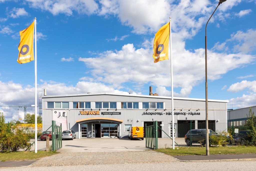 Stenyxegatan 20 Malmö, grå byggnad mot blå himmel. Gul flagga syns i bilden.